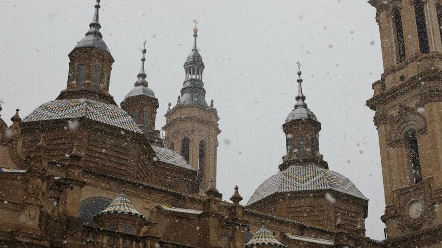 La nieve deja imágenes de postal en la Basílica del Pilar desde la plaza y el puente de Piedra