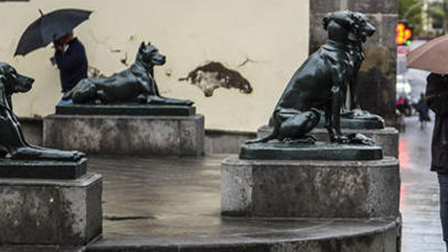 Peatones se refugian de la lluvia en la plaza de Santa Ana, en una foto de archivo.