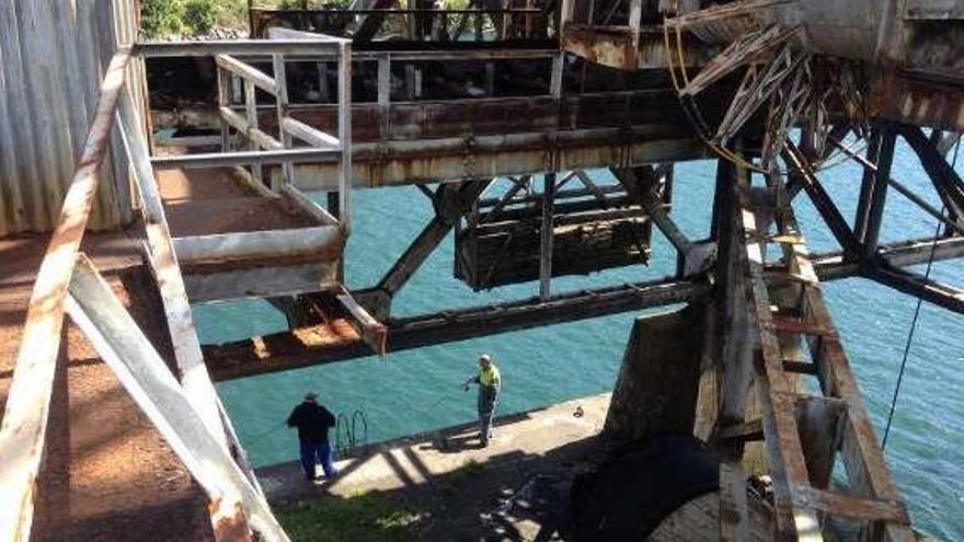 Pescadores bajo la destartalada estructura del muelle. // A.O.