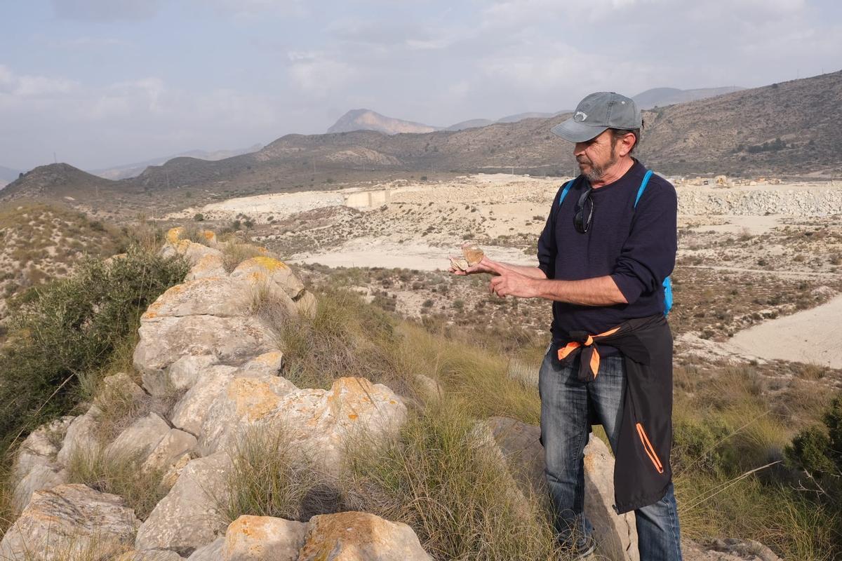 Obrador Gil observando los fósiles y al fondo las canteras de Piedra Natural Bateig.