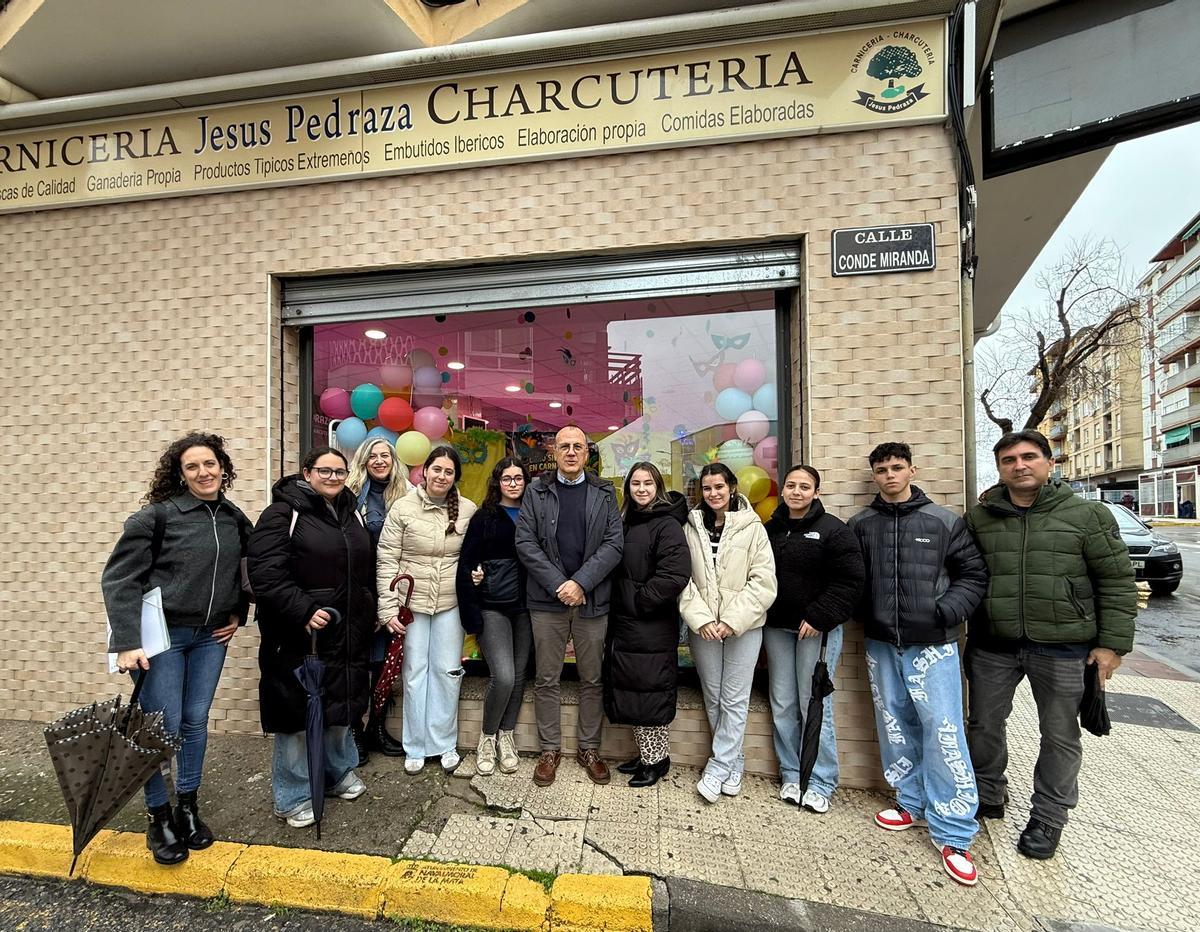 El alcalde y alumnos del IES Zurbarán, frente a uno de los escaparates participantes.