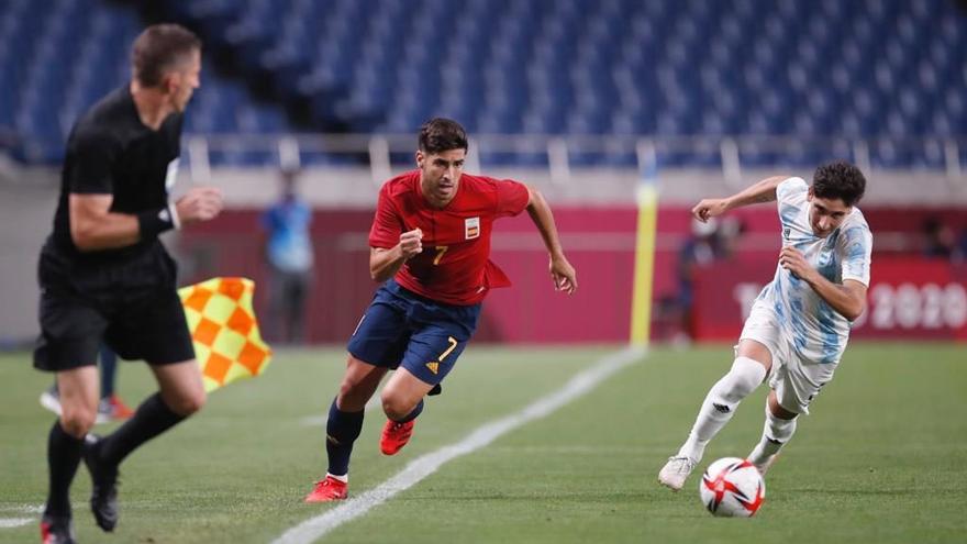 Marco Asensio, perseguido por el defensa argentino Bravo