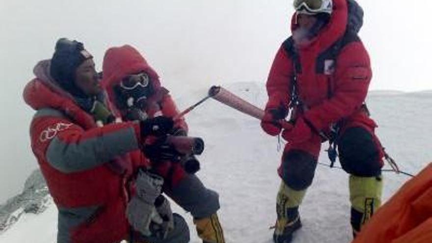 Fotografía de cortesía que muestra a Luobuzhandui encendiendo la llama olímpica  de Pekín sostenida por el portador Jiji en la cima del Everest a 8844.43 Mts de altura.