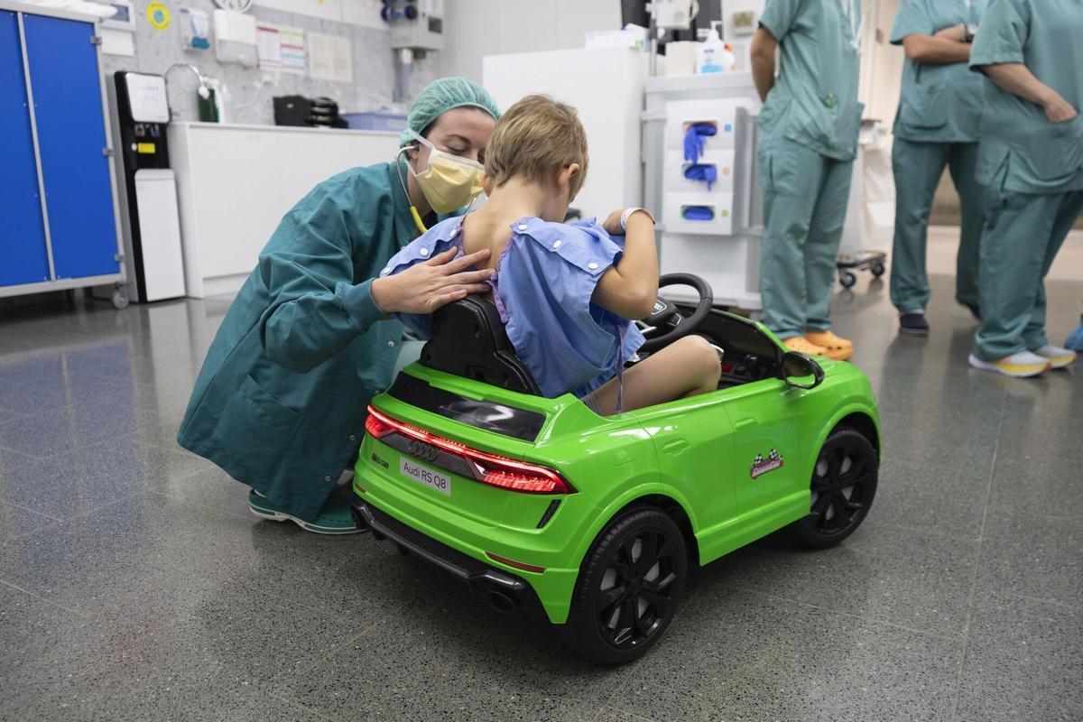 Un niño conduciendo un coche eléctrico de juguete de camino al quirófano
