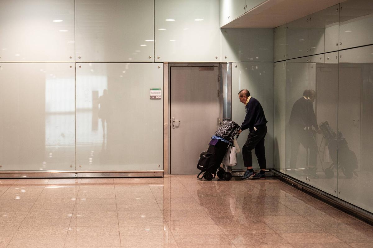 Dominic, un hombre de 78 años con graves problemas de mobilidad, recoge sus pertenencias tras ser expulsado de un vestíbulo de la terminal T1.