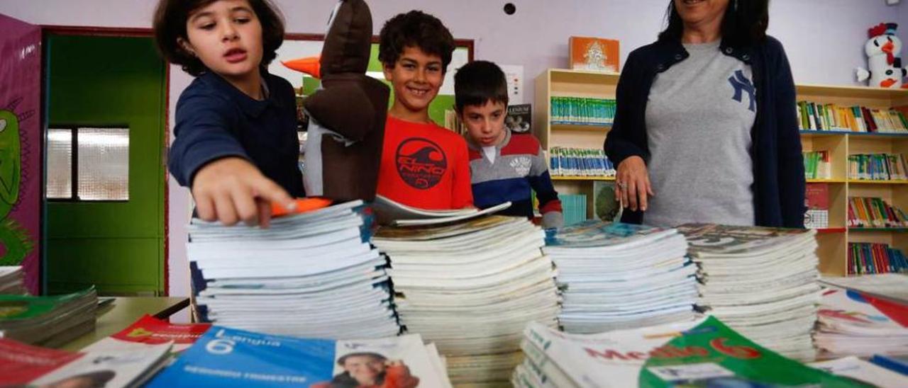 Alumnos del colegio Juan Ochoa, en el banco de libros del centro, junto a la directora, Loles del Campo, al comienzo de un pasado curso.