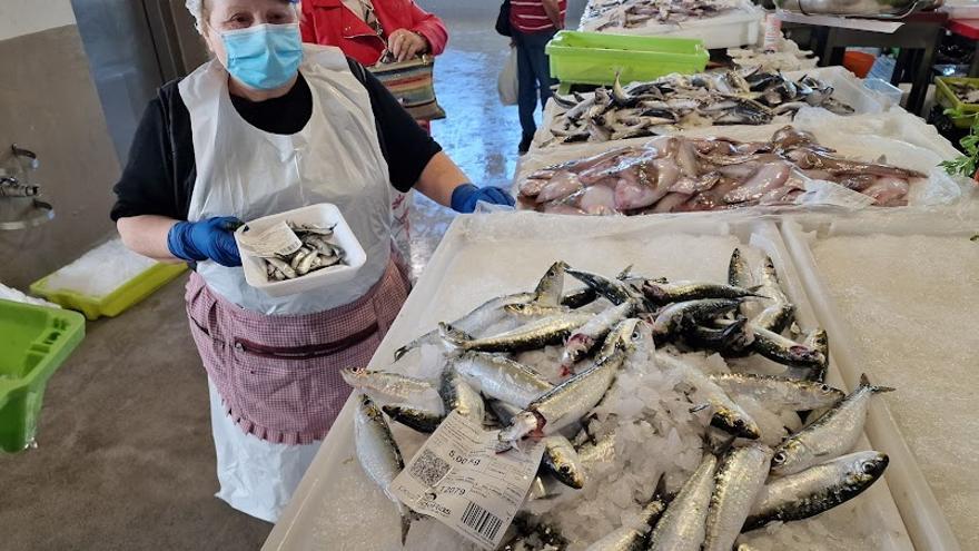 María del Carmen Soto, ante una caja de sardinas y con una bandeja de "xoubiñas" que adquirió en la lonja de Cambados y vendió en la plaza de Vilagarcía a 18 euros el kilo.