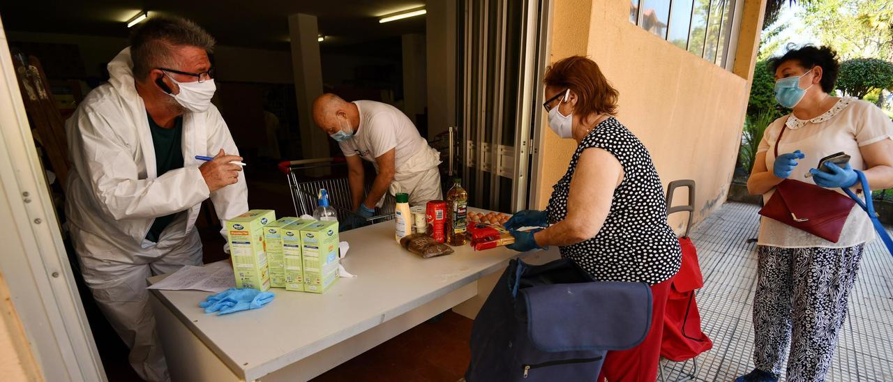 Voluntarios del banco de alimentos de Monte Porreiro repartiendo diferentes productos.