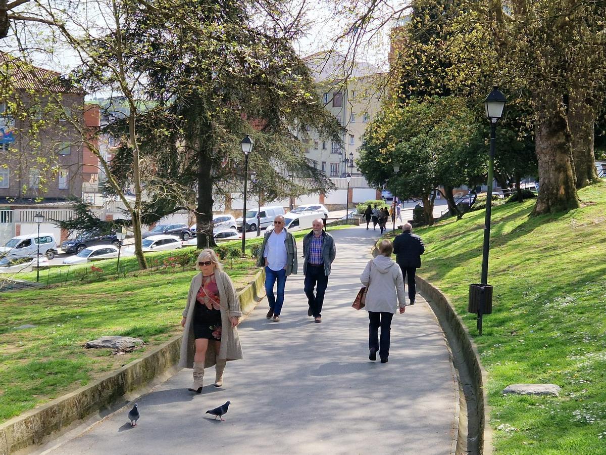 Viandantes en el paseo dedicado a LuisPrieto Bances en el parque del Campillín.