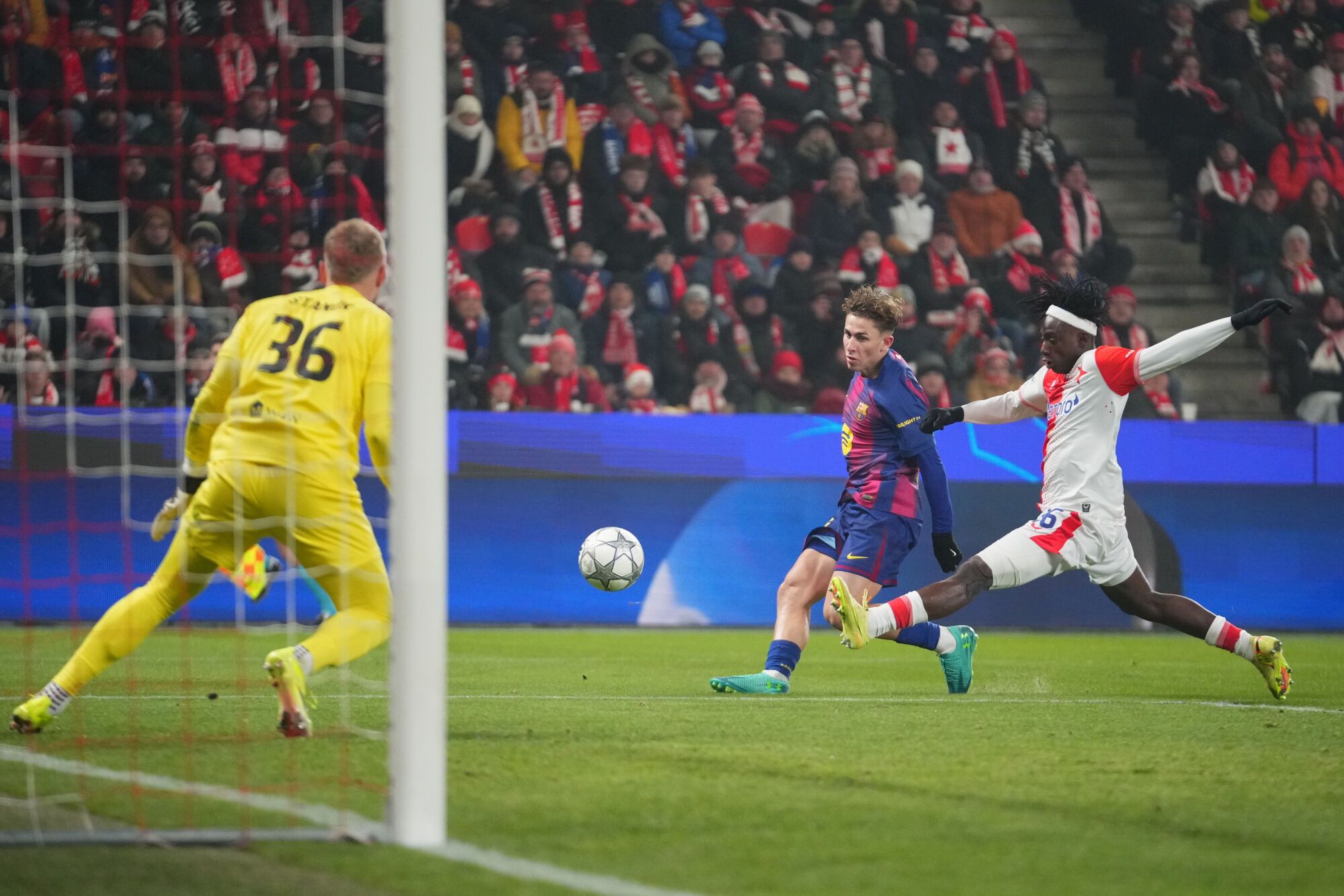 Barcelona's Fermin Lopez, center, scores his side's opening goal past Slavia's David Moses, right, and Slavia's goalkeeper Jindrich Stanek during the Champions League opening phase soccer match between Slavia Prague and Barcelona in Prague, Czech Republic, Wednesday, Jan. 21, 2026. (AP Photo/Petr David Josek)