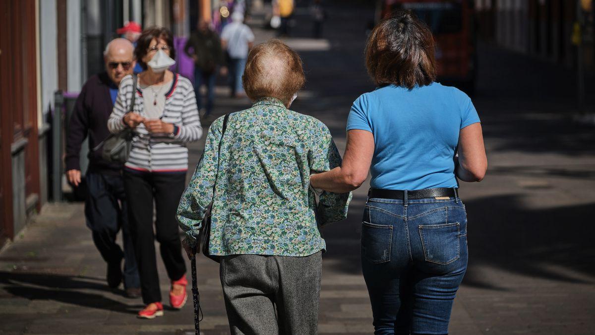 Una persona mayor camina acompañada