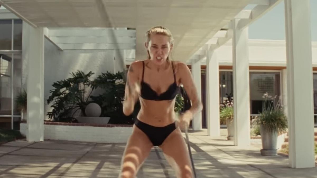 Miley Cyrus realizando fitness en un videoclip