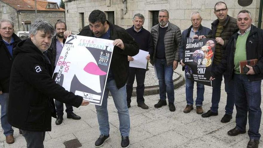 Marcos Pereiro e Pepo Suevos mostran o cartel festeiro diante do concello, en presenza do alcalde e membros da comisión. // Bernabé/Javier Lalín