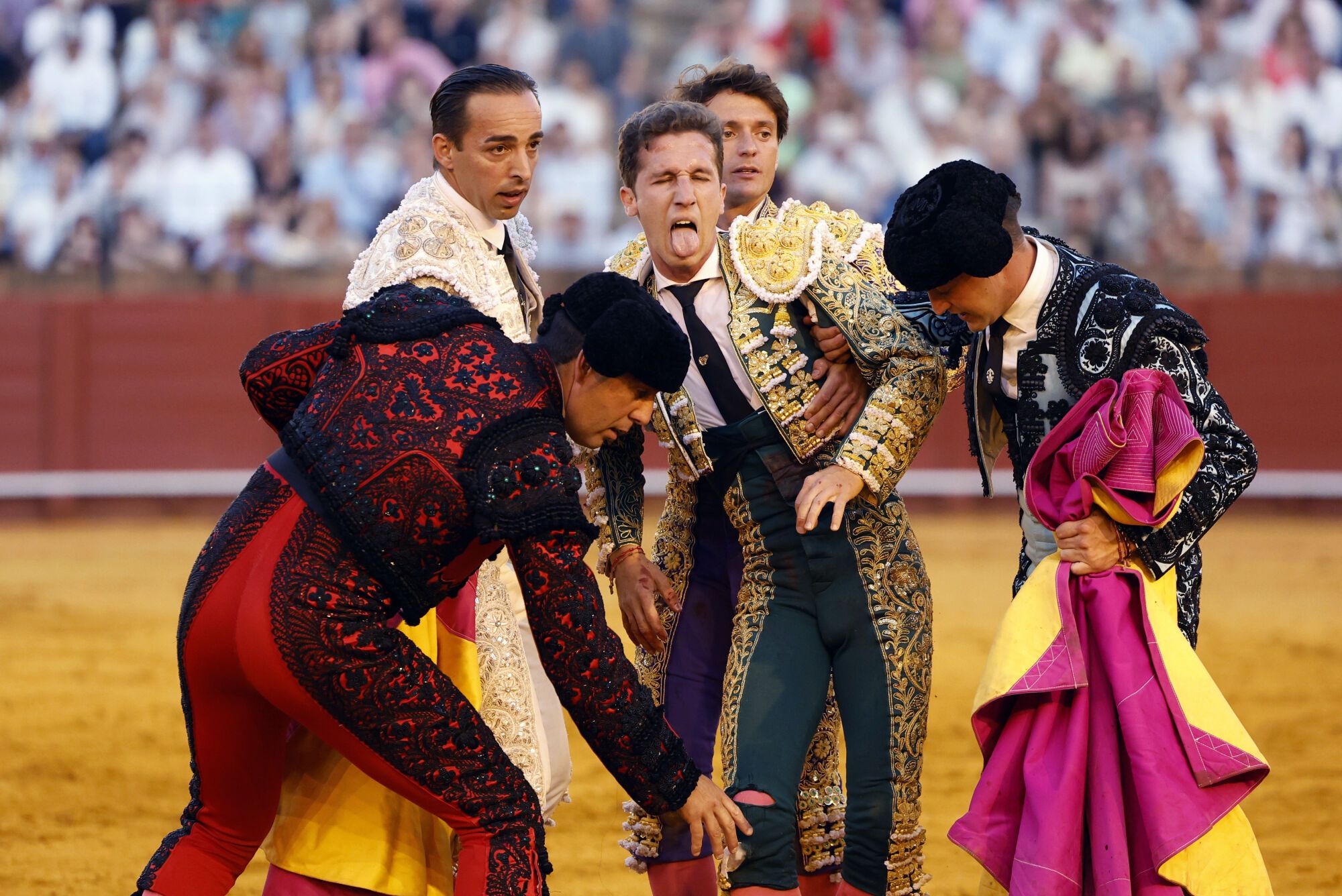 SEVILLA , 27/04/2025.- El diestro Juan Pedro García "Calerito" (c) asistido por su cuadrilla tras ser volteado por el segundo de sus astados durante la corrida de la Feria de Abril celebrada este domingo en la plaza de toros de la Maestranza, en Sevilla. EFE/ Julio Muñoz