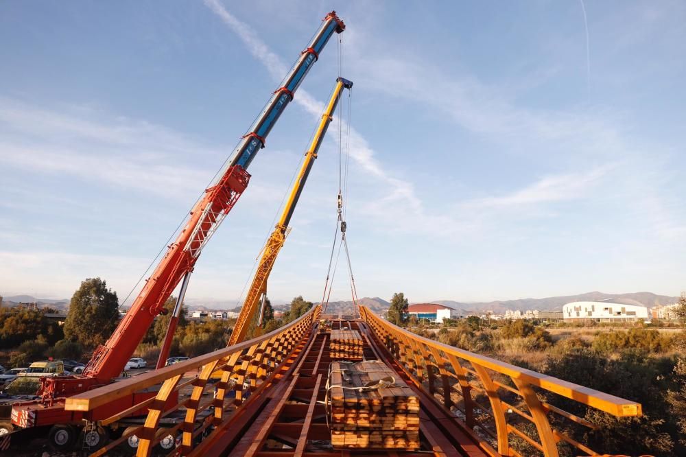 Comienzan a instalar la nueva pasarela de madera del Guadalhorce