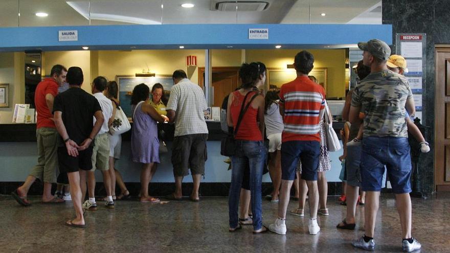 Turistas llegan con sus maletas a un alojamiento hotelero de La Manga del Mar Menor, en una fotografía de archivo.