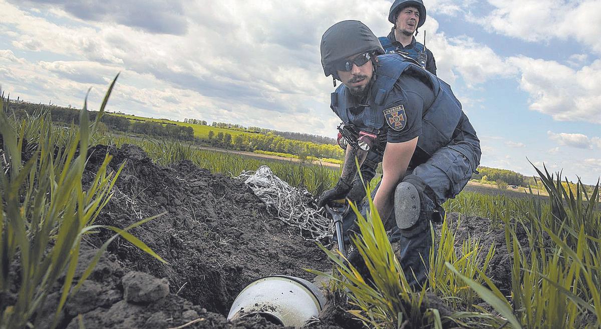 Militars ucraïnesos retiren fragments d’una bomba de dispersió als voltants de la ciutat ucraïnesa de Khàrkiv, el juny del 2022.