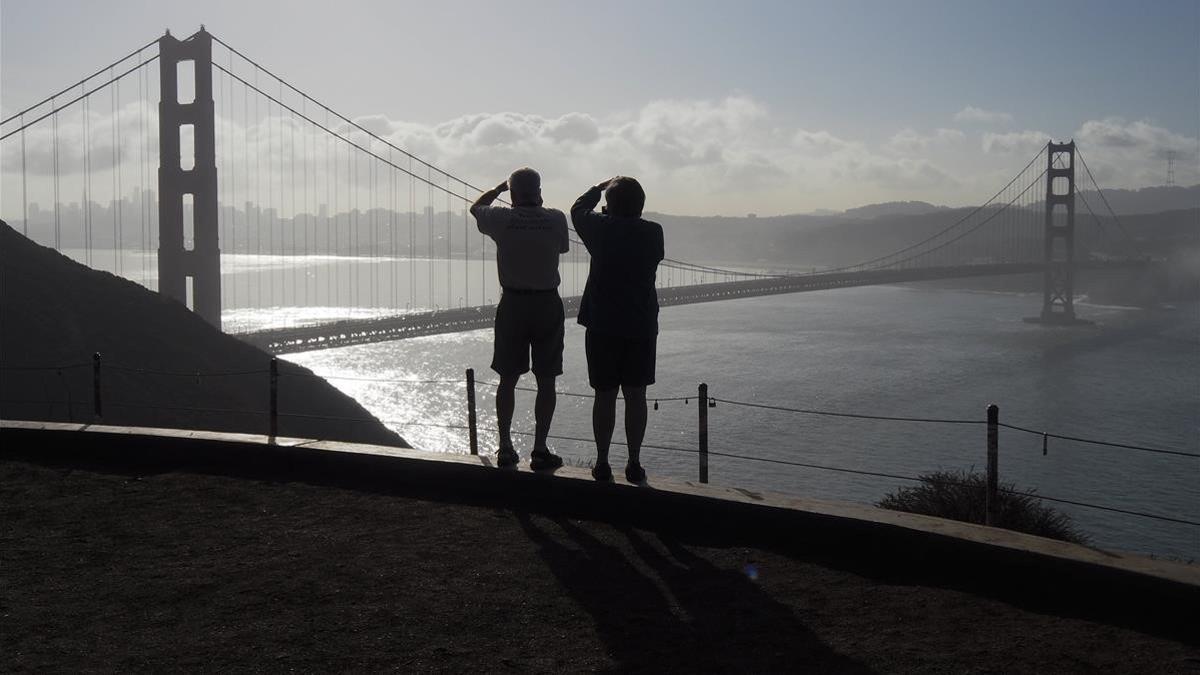 Dos turistas toman fotos del Golden Gate Bridge, en San Francisco, en una imagen de archivo.