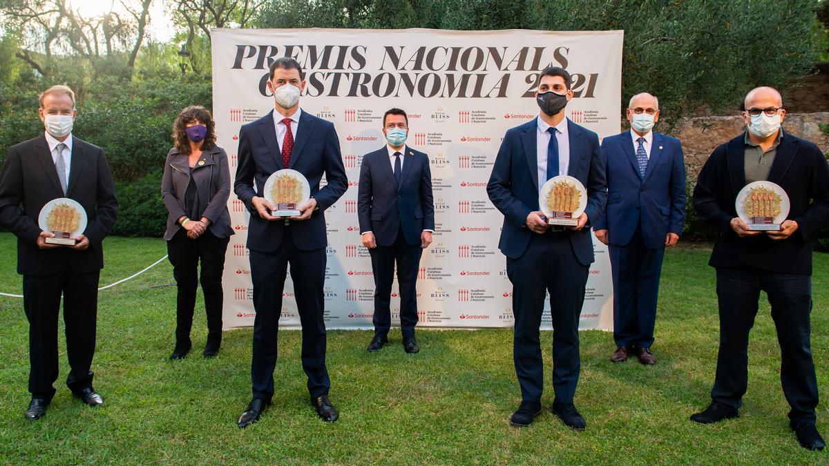 De izquierda a derecha, los galardonados: el representante de Assocome (Premio Especial de la Acadèmia), Javier Oliveira (Via Veneto, Premio Jefe de sala), Rafel Muria (chef de Quatre Camins y Premio Revelación) y Jordi Vilà (Premi Nacional de Gastronomia). Detrás, la 'consellera' de d’Acció Climàtica, Alimentació i Agenda Rural, Teresa Jordà; el 'president' de la Generalitat, Pere Aragonès, y el presidente de la Acadèmia Catalana de Gastronomia i Nutrició, Carles Vilarrubí.