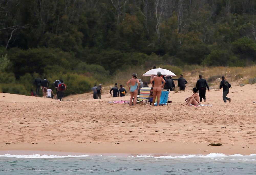 Una patera llega a una playa de Cádiz ante la mirada de los bañistas