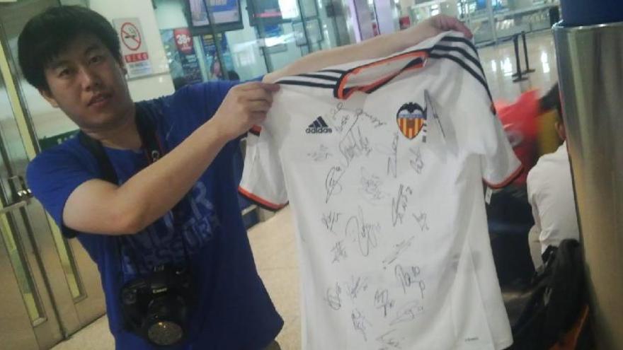 Un aficionado chino se lleva la camiseta firmada.