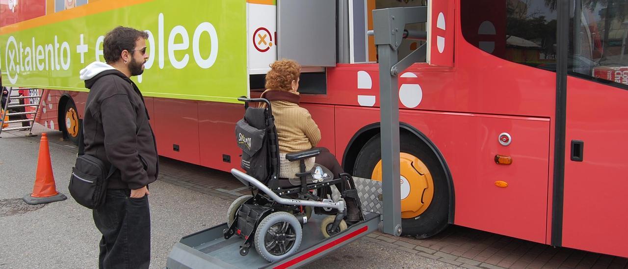 Una mujer en silla de ruedas accede a un punto de información sobre el empleo.