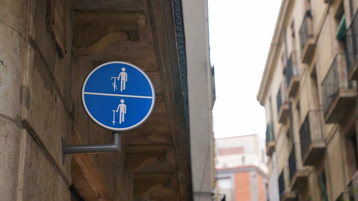 Señal que obliga a bajar de la bicicleta o patinete en una calle de Barcelona