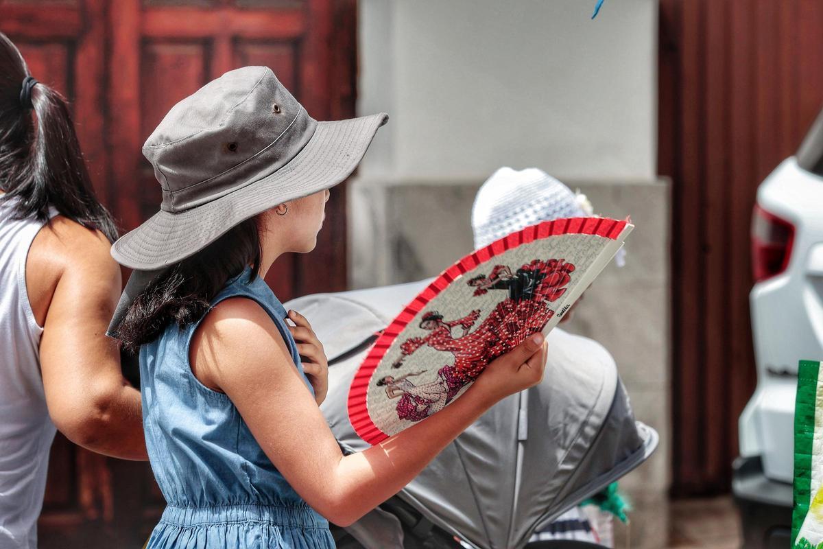 Una niña se resguarda del calor y se abanica durante la ola de calor de octubre en Canarias.