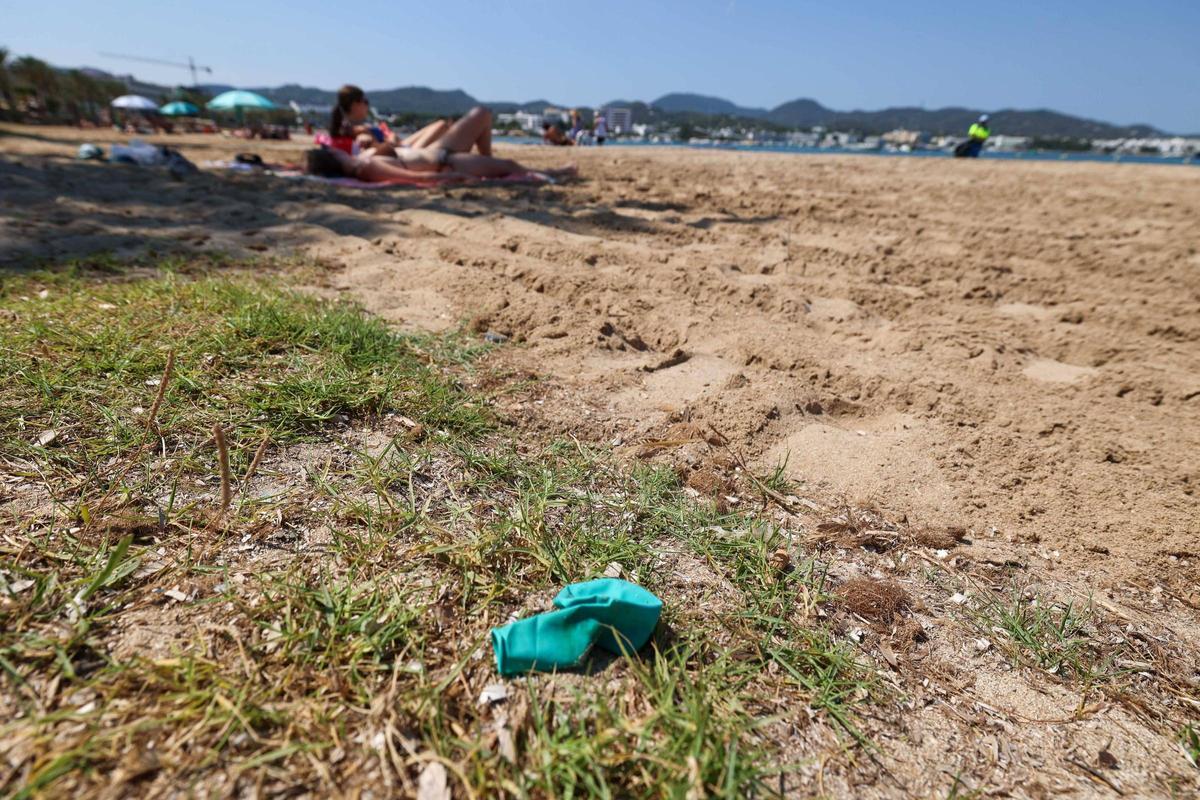 Un globo usado y tirado en medio de la playa