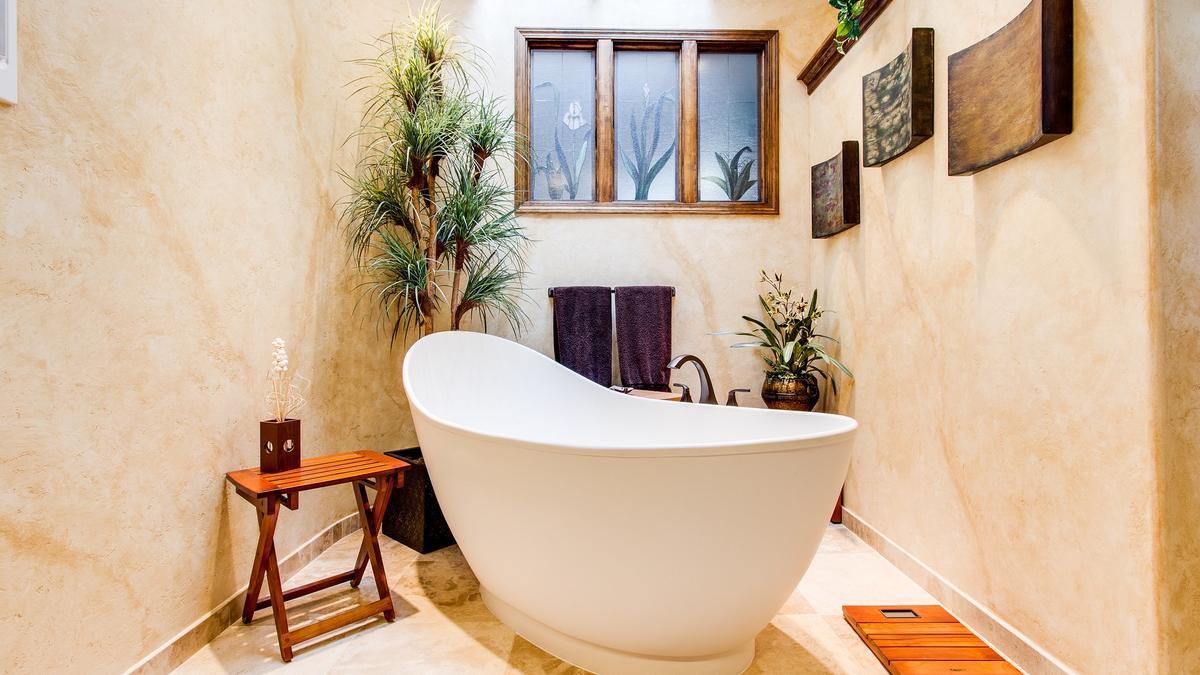 Mujer haciendo limpieza de baño en casa, pared de azulejos de