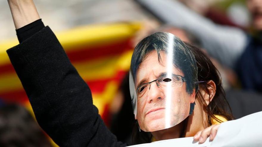 Una mujer protesta con una careta de Puigdemont.