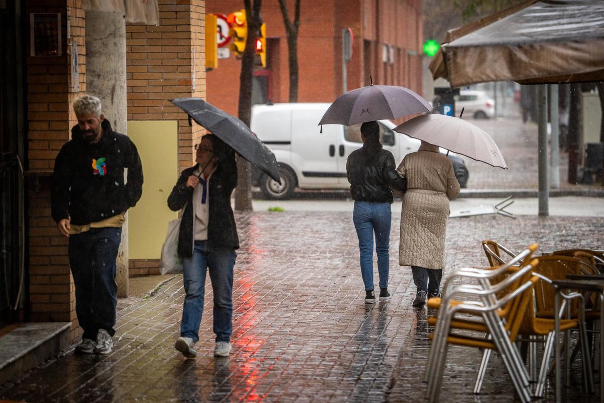 Gente bajo la lluvia en Barcelona.