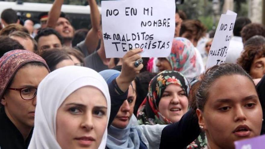 Dones musulmanes amb cartells en la concentració en condemna del terrorisme a la Rambla.