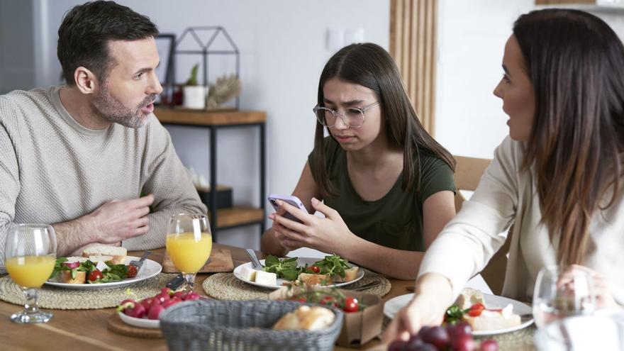 Imagen de unos padres con su hija adolescente.