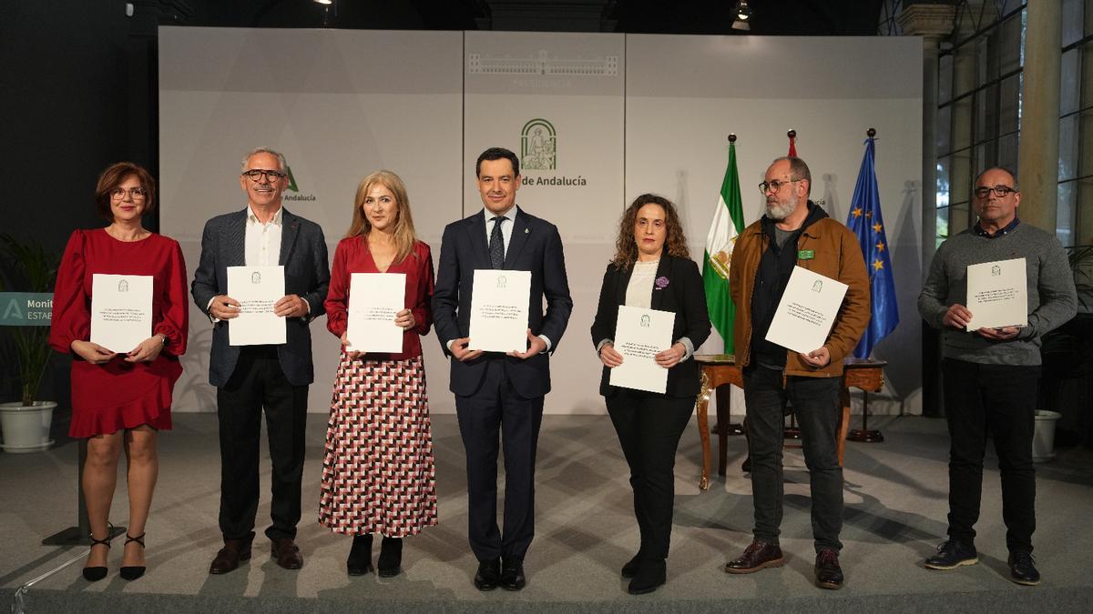 Juanma Moreno, en el centro, muestra el acuerdo para los monitores escolares.