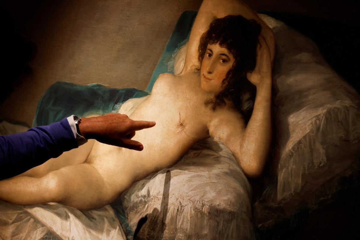 Un hombre señala una réplica de 'La maja desnuda' del pintor español Francisco de Goya que muestra un seno mastectomizado en el Museo Thyssen.