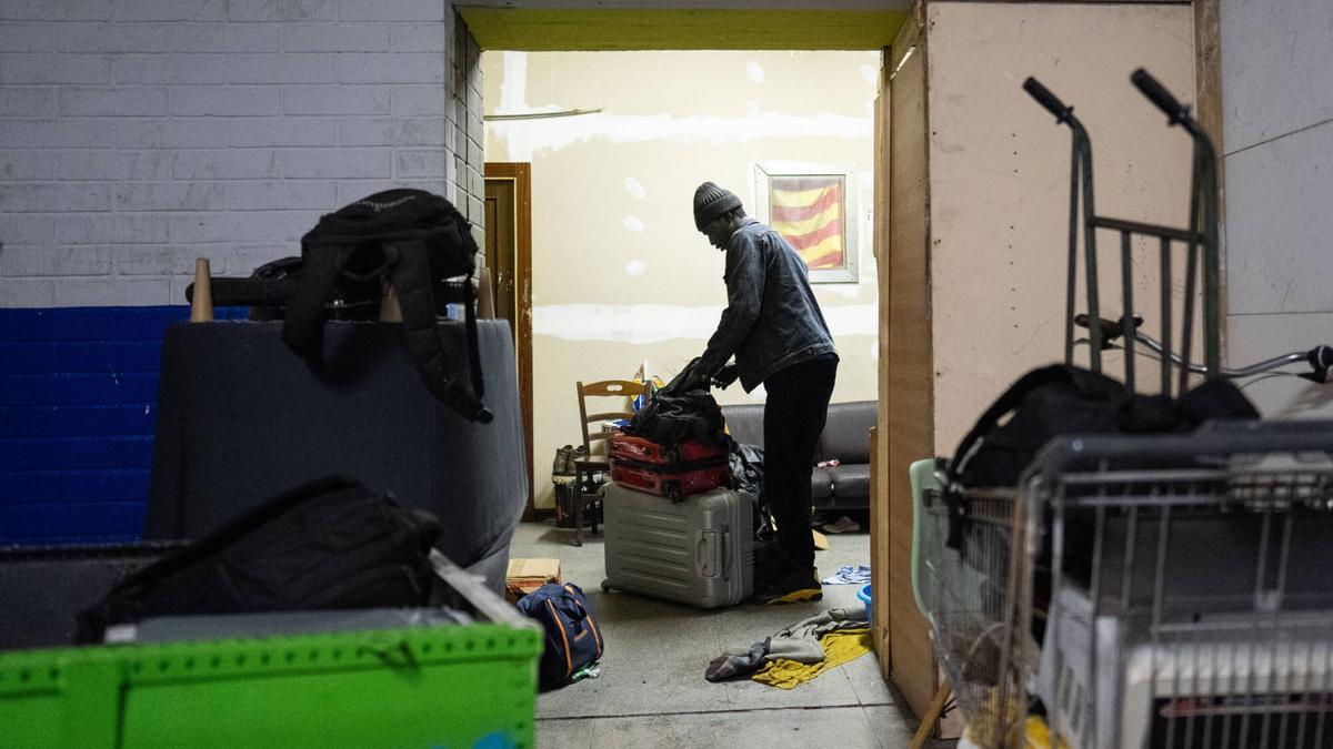 Un hombre recoge sus pertenencias momentos antes de que la policía desaloje el antiguo instituto ocupado B9 de Badalona