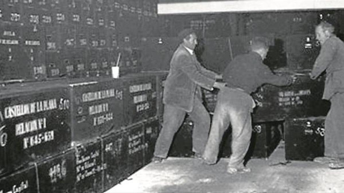 La caja con restos de asesinados en Aldeaseca (Ávila), manejada por enterradores en el Valle de los Caídos en 1959