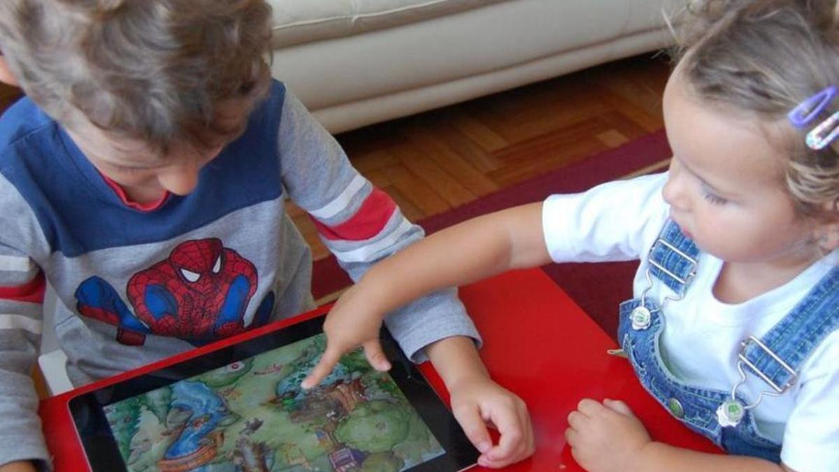 Dos niños juegan con una tablet.