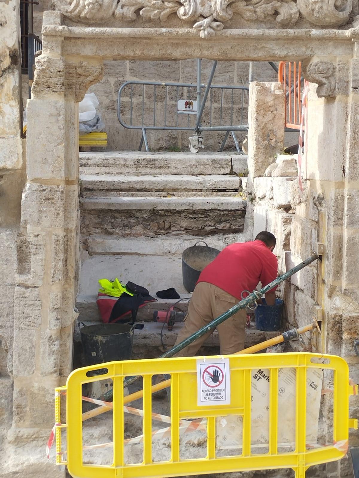 Un operario, trabaja en la escalera que da acceso a la iglesia.