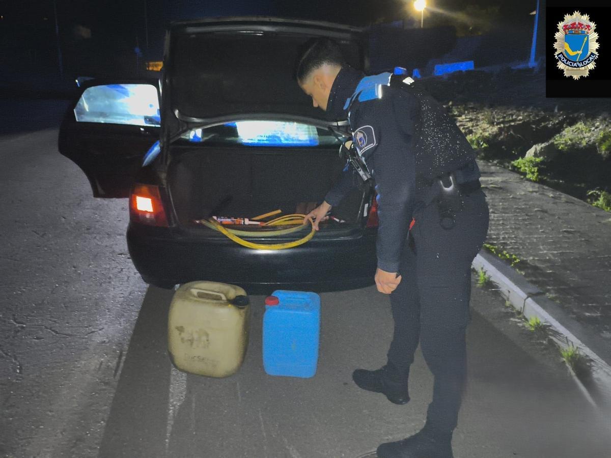 Un agente, con garrafas y el coche que utilizaban los detenidos