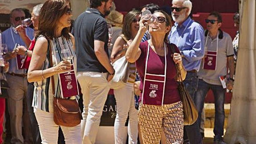 Varias personas catan vinos de Toro durante una feria.