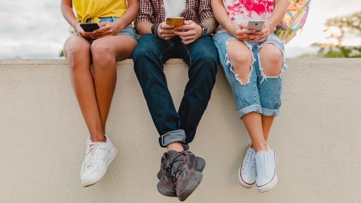 Joves amb mòbils a les mans