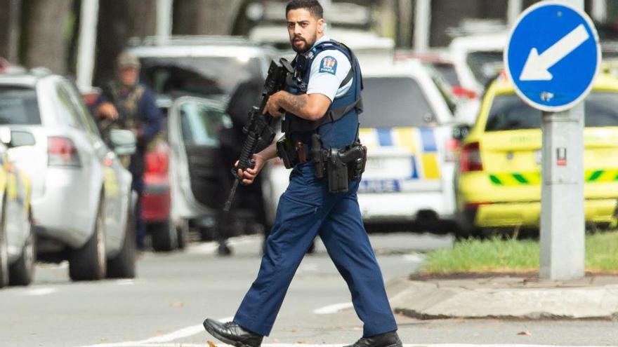 Un policía, hoy sí armado, en la zona del ataque. // EFE