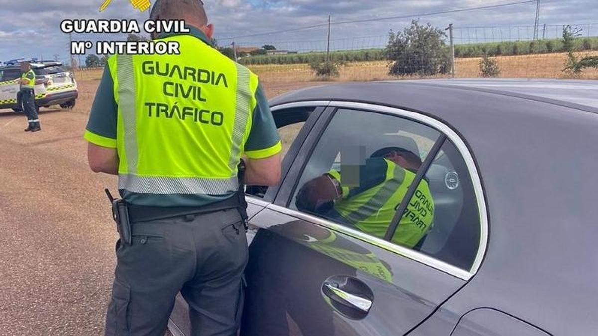 Un guardia civil de Tráfico solicita la documentación a un conductor.