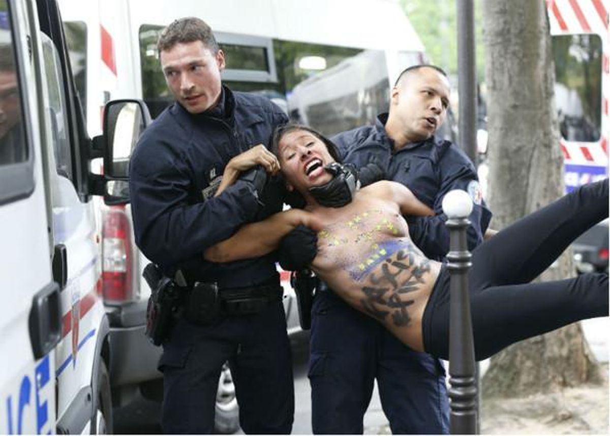 Una de les activistes de Femen és reduïda per la policia francesa.