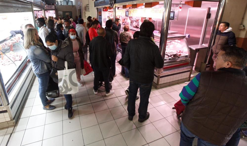 Gran afluencia y clientes con mascarillas en el Mercado Central por la amenaza del coronavirus en Alicante