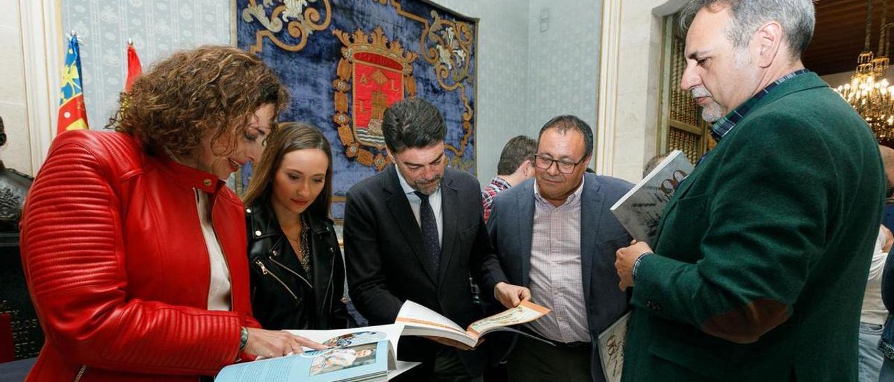 Autoridades y festeros observan el libro presentado este miércoles