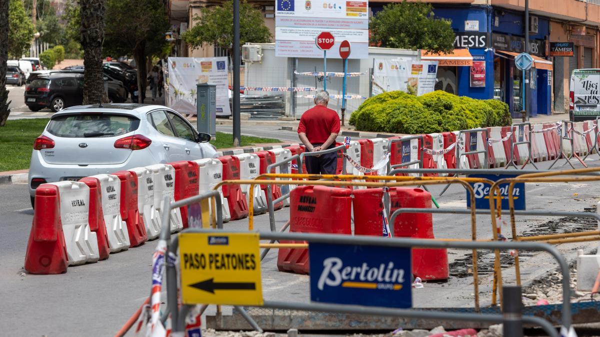 Un hombre cruza la avenida de Jijona a través del paso habilitado por las obras.