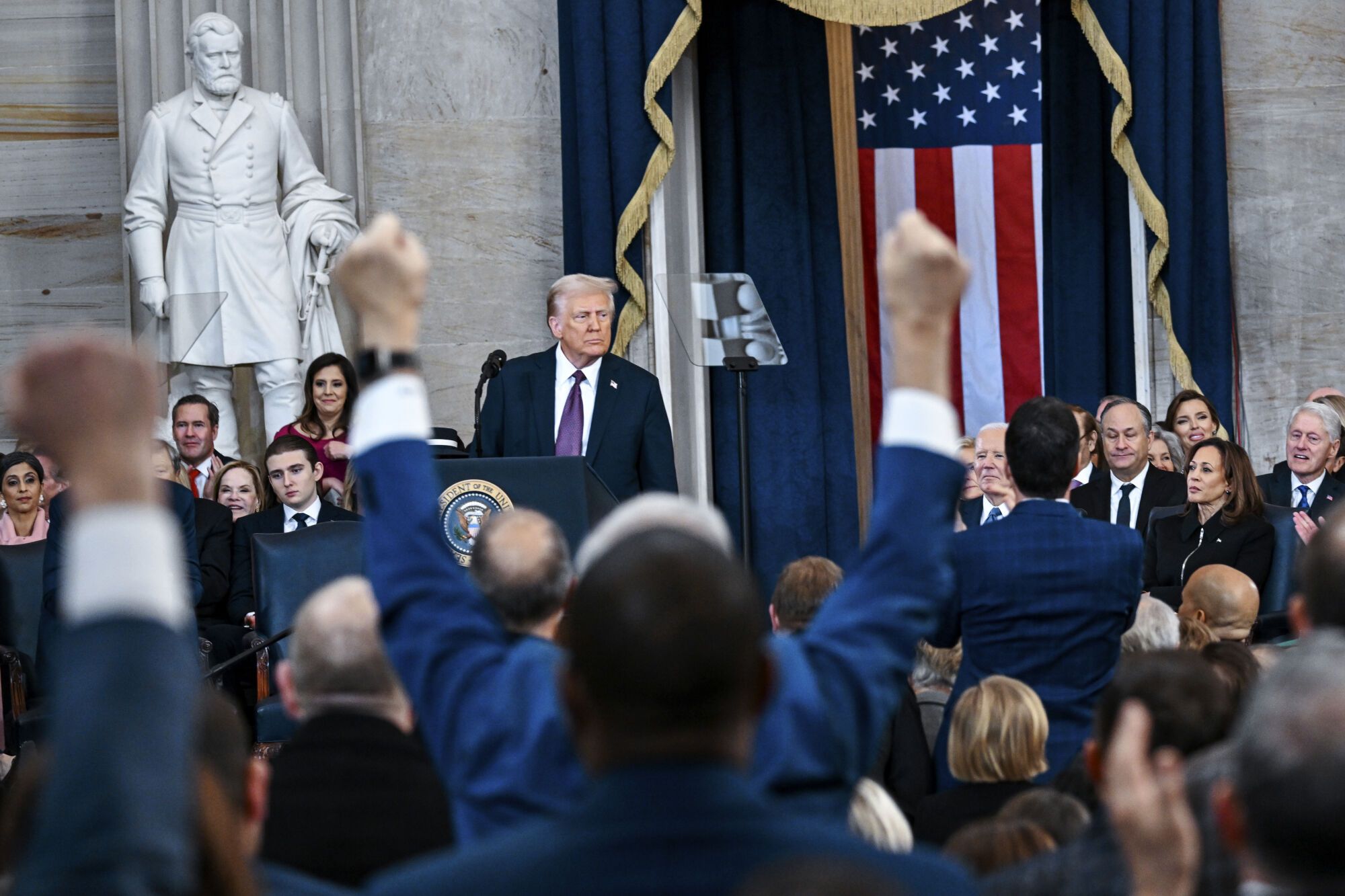 Attendees cheer as President Donald Trump speaks after taking the oath of office during the 60th Presidential Inauguration in the Rotunda of the U.S. Capitol in Washington, Monday, Jan. 20, 2025. (Kenny Holston/The New York Times via AP, Pool). POOL PHOTO; MANDATORY CREDIT